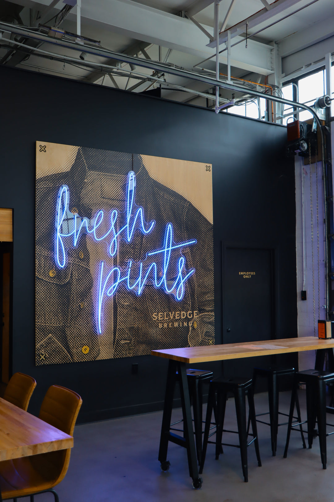 Neon sign reading 'fresh points' in a bar setting with tables and chairs.