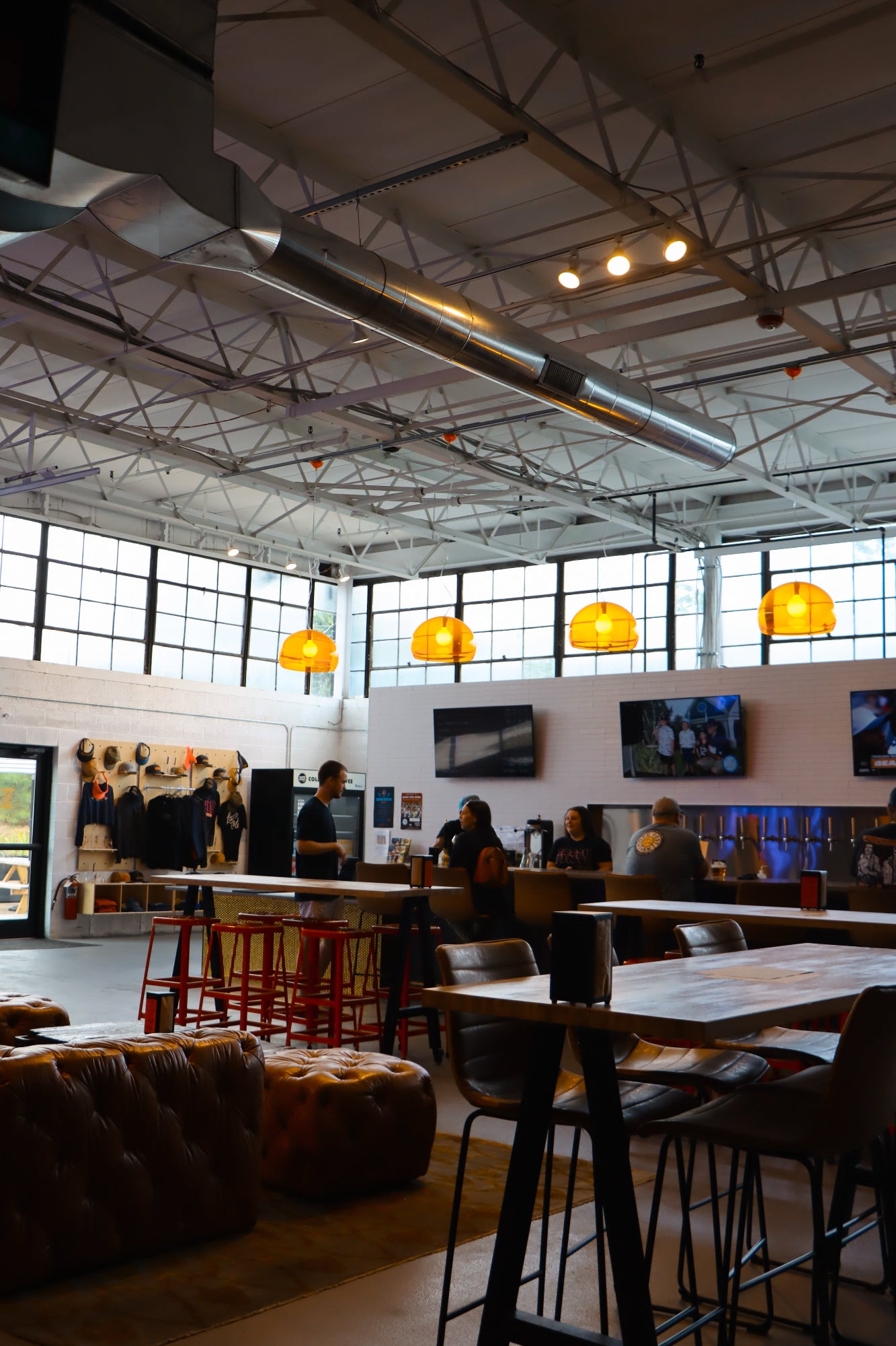 Modern interior of Selvedge with high ceilings, large windows, and industrial-style decor.
