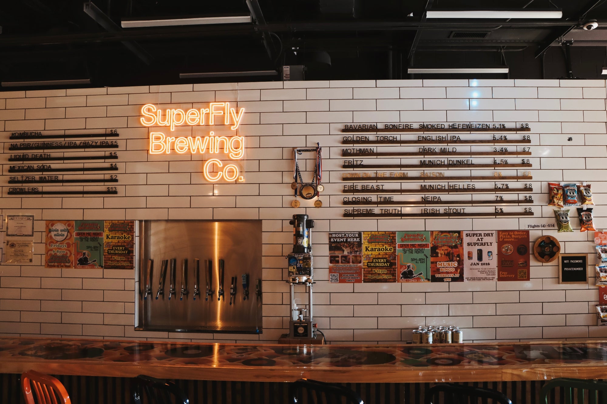 Bar area with SuperFly Brewing Co. neon sign on a tiled wall.
